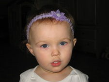 Here Presley is wearing our Silk Flower Headband in Lavender.